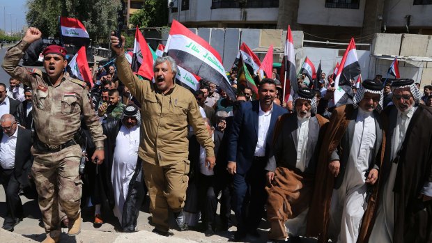 Iraqi Shiites wave the national flag as they celebrate victory over IS in the Iraqi city of Tikrit.