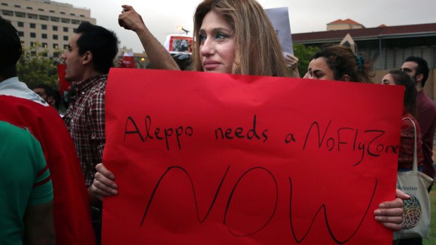 A Syrian woman holds a sign during a protest against Basha al-Assad's military operations, in front of the UN headquarters in Beirut. 
