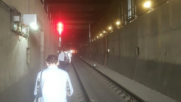 Commuters walk through the City Loop after power outages halted their train. 