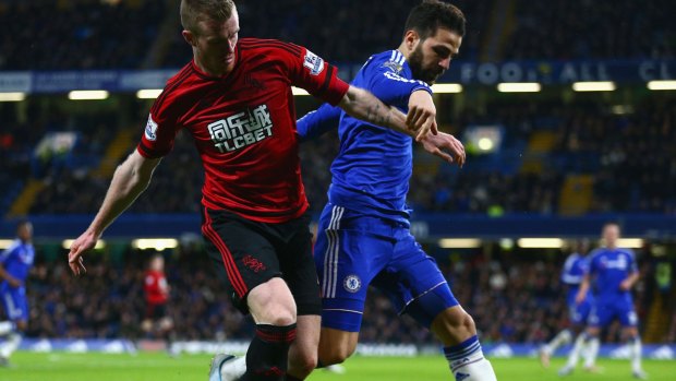 Cesc Fabregas of Chelsea and Chris Brunt of West Bromwich Albion compete for the ball.