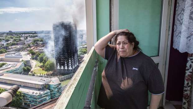 Local resident Georgina stands distraught on her balcony after a fire engulfed the 24-storey Grenfell Tower.