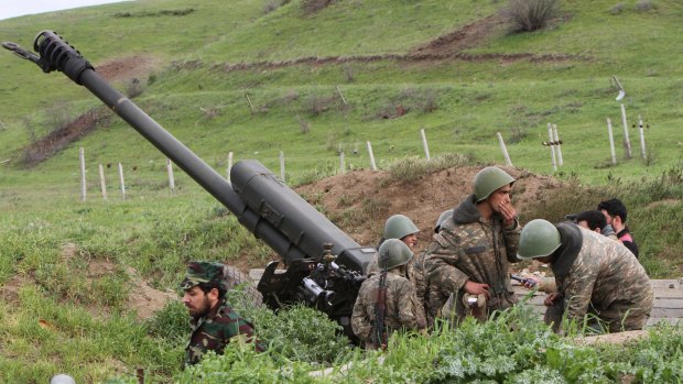 Karabakh Armenian soldiers stand near a howitzer.