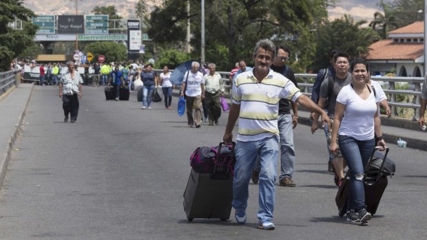 People walk across the Simon Bolivar bridge on the Venezuela-Colombia border after Venezuela intensified deportations of Colombians.