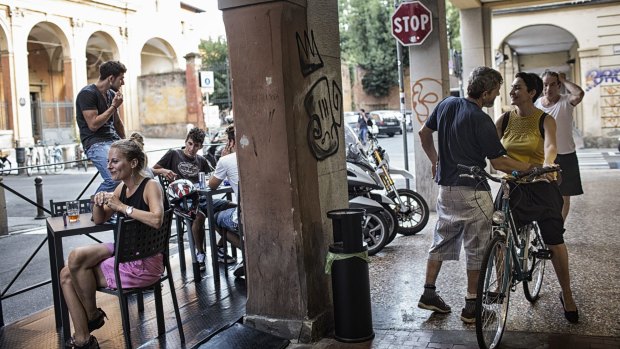 Neighbours socialise at the corner bar on Via Fondazza, the founding street of Social Street in Bologna, Italy.