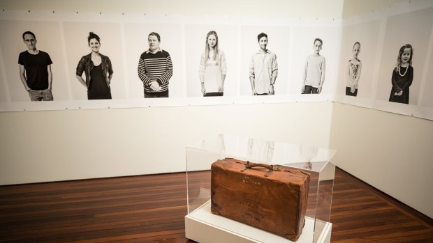 A suitcase and a series of portraits by Linda Wachtel feature in The Gift, an exhibition about migration at the Museum of Australian Democracy at Old Parliament House.