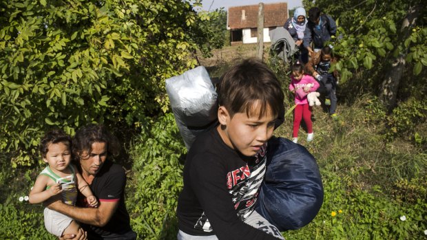 A family of refugees in Horgos, Serbia,  rush towards the border with Hungary after hearing a rumour (which turned out to be false) that the Hungarian authorities had opened the crossing. 