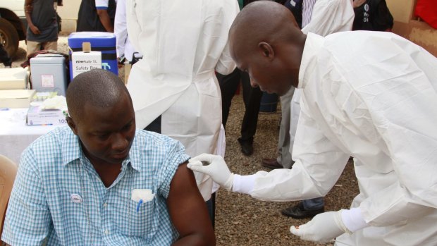 A health worker cleans a man's arm before injecting him with a Ebola vaccine  in Conakry, Guinea, in March.