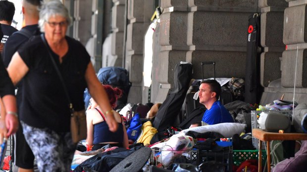 A man sits at the homeless camp outside Flinders Street Station.