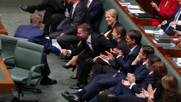 Opposition Leader Bill Shorten shakes hands with shadow treasurer Chris Bowen after he attacked the government during question time.