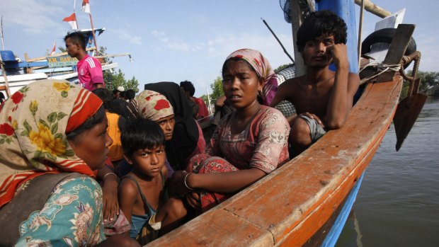 Rescued migrants sit on an Acehnese fishing boat upon arrival in Indonesia.