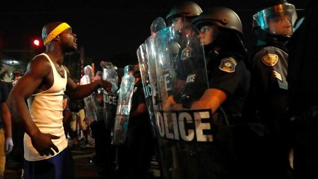 A man yells at police in riot gear just before a crowd turned violent in St Louis.