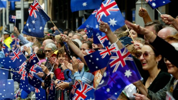 The flag-waving crowd on George Street, Sydney, as the Anzac Day march passes by. 