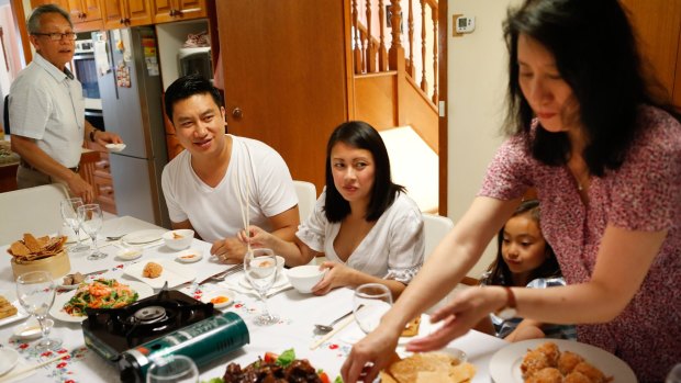 Bao Hoang, seated, with his wife and parents during dinner at the family home. 