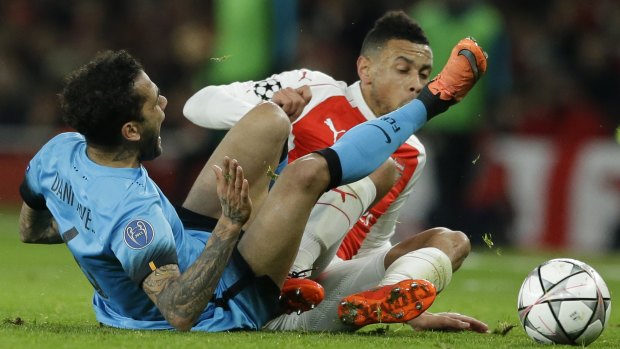 End in sight? Barcelona's Dani Alves, left and Arsenal's Francis Coquelin clash during a recent Champions League tie.
