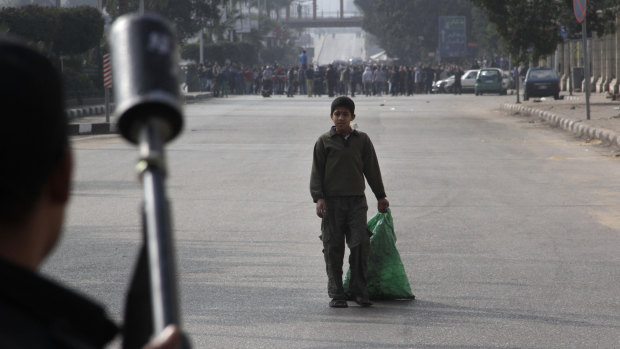Divided nation: A boy looks at security forces as they try to disperse Mursi supporters in Cairo on Friday.