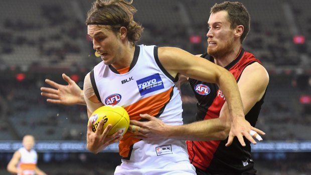 Giants backman Phil Davis tackled by Bombers ruckman Matthew Leuenberger at Etihad in June.