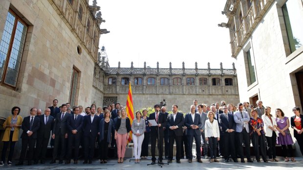 The leader of Spain's Catalonia region, Carles Puigdemont, centre, announces the referendum surrounded by members of his cabinet, in Barcelona, on Friday.