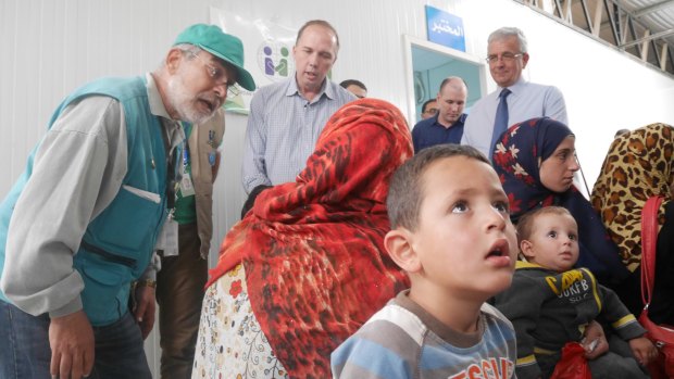 Immigration Minister Peter Dutton talks to a refugee family at a medical clinic at the camp.