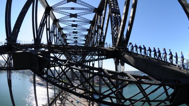 Don't look down: Cars zoom below bridge climbers.