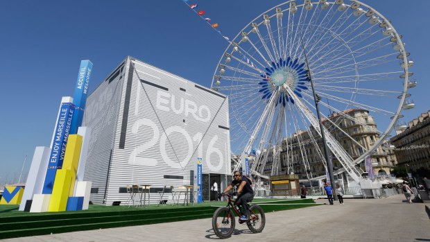 A man rides in front of a Euro 2016 meeting point in the Old Port of Marseille as France prepares for the biggest-ever European Championship.