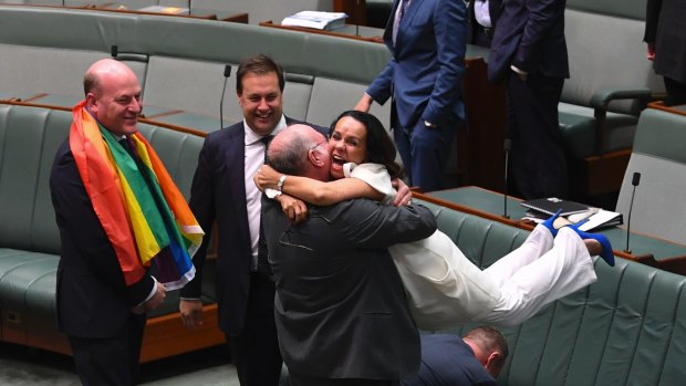 Liberal MP Warren Entsch lifts Labor MP Linda Burney into the air after the same-sex marriage vote.