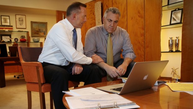 Prime Minister Tony Abbott poses with the Treasurer Joe Hockey as they look through Budget papers in Canberra on Tuesday.