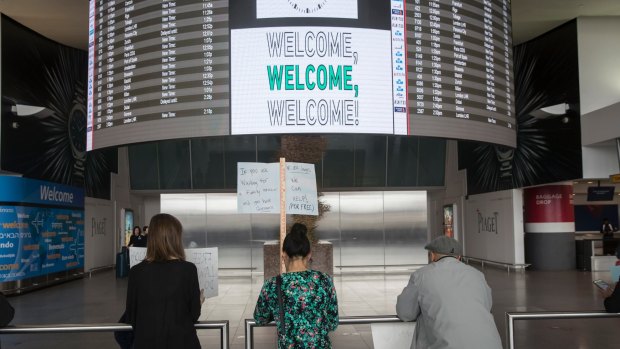 Volunteer lawyers greet arriving passengers in New York earlier this year as Donald Trump's travel ban heralded an immigration crackdown.