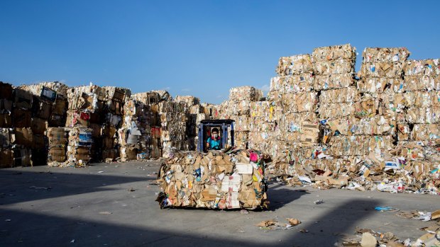 'Of course, Iran's economy will also grow': An Iranian employee relocates paper waste at the Pardis Kaghaz Pazh recycled paper factory in Neyshabur.