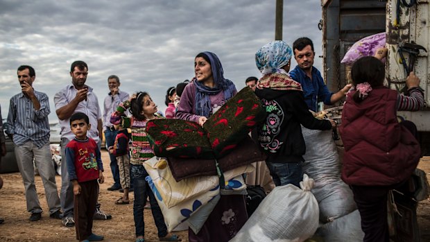 A family hurries to board a truck bound for shelter for Syrian Kurdish refugees in Yumurtalik, Turkey, in September 2014. Turkey is refuge to more Syrian refugees than any other country.