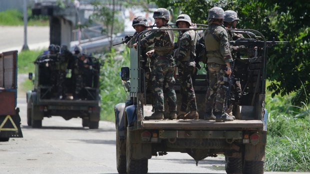 Philippine troopers ride their vehicles in Marawi. It's unclear how many people remain trapped in the city. 