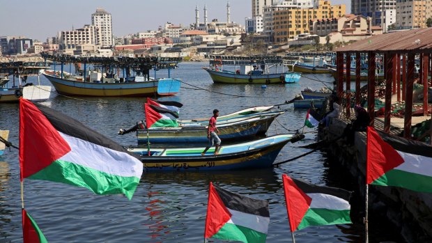 A Palestinian walks on a boat decorated with national flags as he awaits the arrival of the 13 pro-Palestinian female activists. 