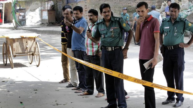 Members of Bangladeshi police stand by the site where Italian citizen Cesare Tavella was gunned down by unidentified assailants in Dhaka, Bangladesh on Tuesday. Islamic State claimed responsibility for the attack.