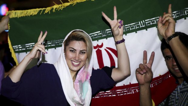 An Iranian woman shows the victory sign as people celebrate on the streets of Tehran following the landmark nuclear deal.