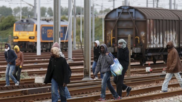 Migrants make their way along train tracks towards the Channel Tunnel on Wednesday. 
