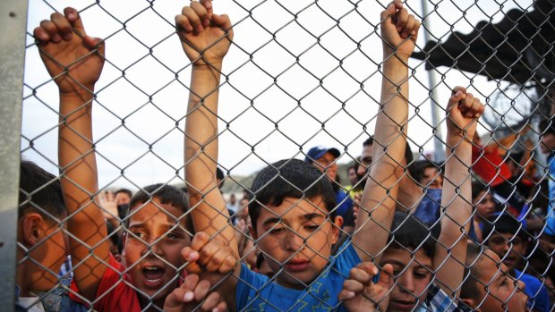Syrian refugee children chant slogans behind a fence at the Nizip refugee camp in Gaziantep province, south-eastern Turkey, following a visit by German Chancellor Angela Merkel and top European Union officials.