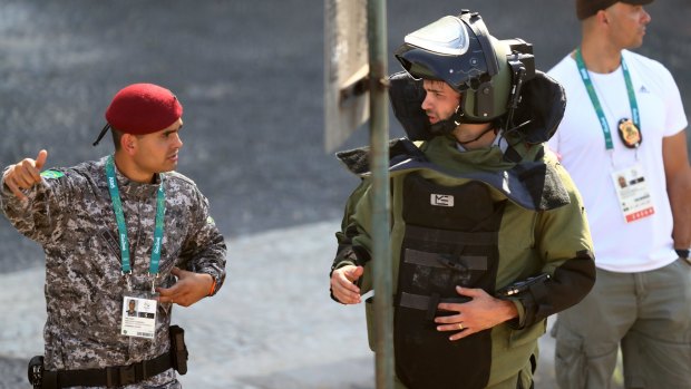 Members of the Brazillian bomb squad carry out a controlled explosion of a bag near the finish line of the Men's Road Race.