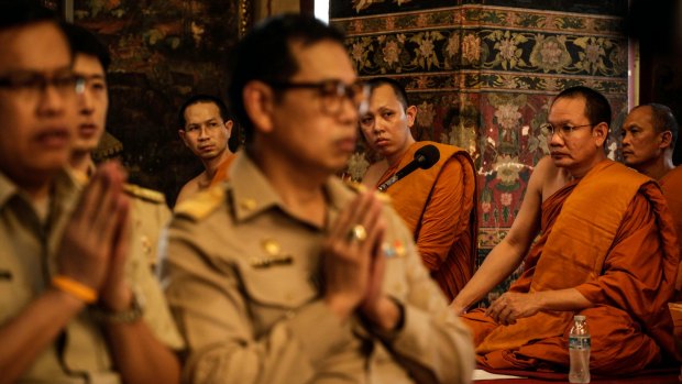 Thai Buddhist monks and officials pray for King Bhumibol Adulyadej at Wat Pathumwanaram temple.