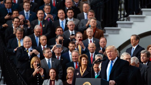 The fans: Republicans take their cameras out to record President Donald Trump celebrating the final passage of tax overhaul legislation by Congress.