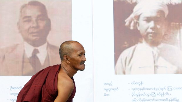 A Buddhist monk views portraits of Myanmar's Independence hero General Aung San.