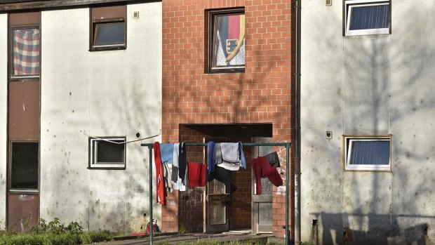 A German flag hangs in a window at a refugee shelter in Recklinghausen, Germany, which police searched on Saturday.