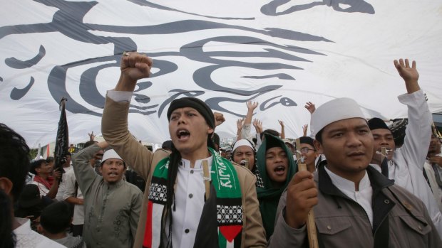 Indonesian Muslims shout slogans during a rally against communism outside the Parliament in Jakarta on September 29.