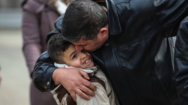 A Syrian who identified himself only as Ali embraces his son Zein from Idlib, Syria, after he crossed into Turkey on Saturday. It was not immediately clear where in Syria most people that crossed into Turkey were coming from but one woman said several people were able to leave  Aleppo. 