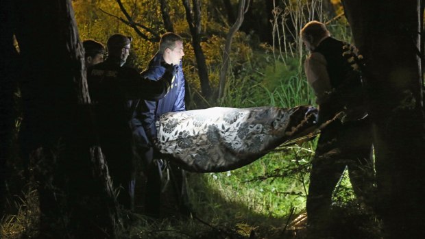 Police remove the body of a woman from bushland in Donvale.
