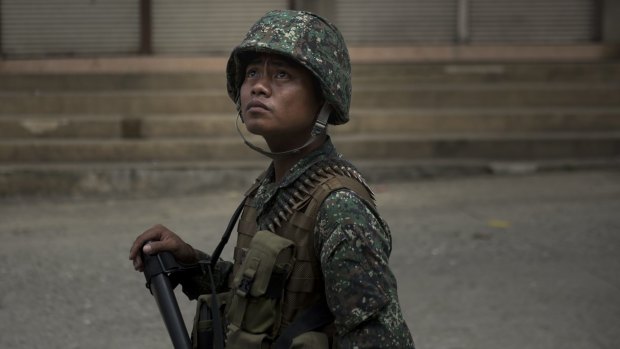 A soldier scans a street for snipers in Marawi city.