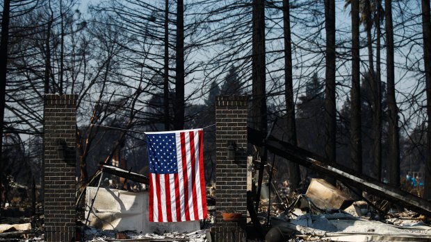 An American flag hangs on a burnt home in Santa Rosa, California, on Sunday.