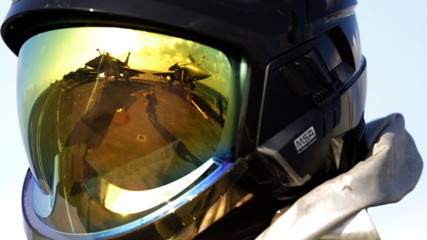 The deck of the French Navy aircraft carrier Charles de Gaulle is reflected in the helmet of a crew member.