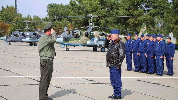 Russian military pilots, right, report upon arrival at an airbase at an undisclosed location in Belarus.