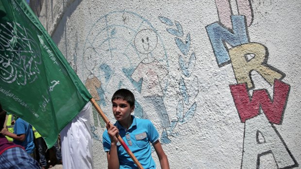 A Palestinian boy holds up a Hamas flag in Gaza on Friday as he demonstrates against a UN Relief and Works Agency (UNRWA) funding gap that could keep 500,000 Palestinian students out of school.