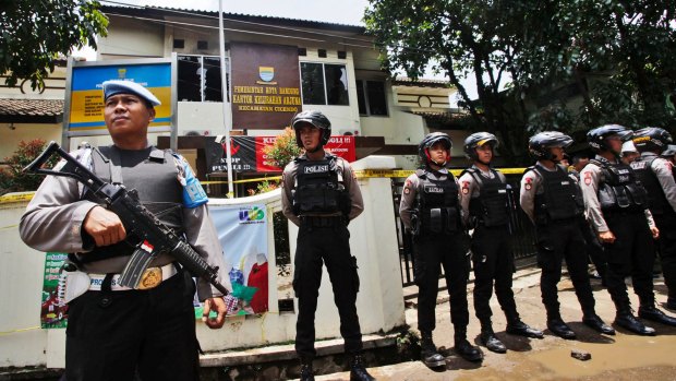 Police officers stand guard outside the municipal building in Bandung where police shot a suspected terrorist on Monday.