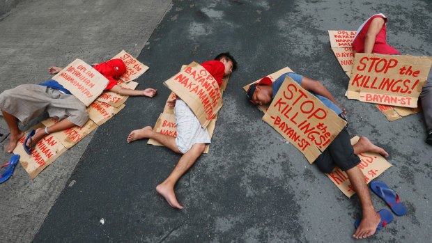 People stage a "die-in" to protest the rising number of extra judicial killings related to Philippine President Rodrigo Duterte's "war on drugs"last year.